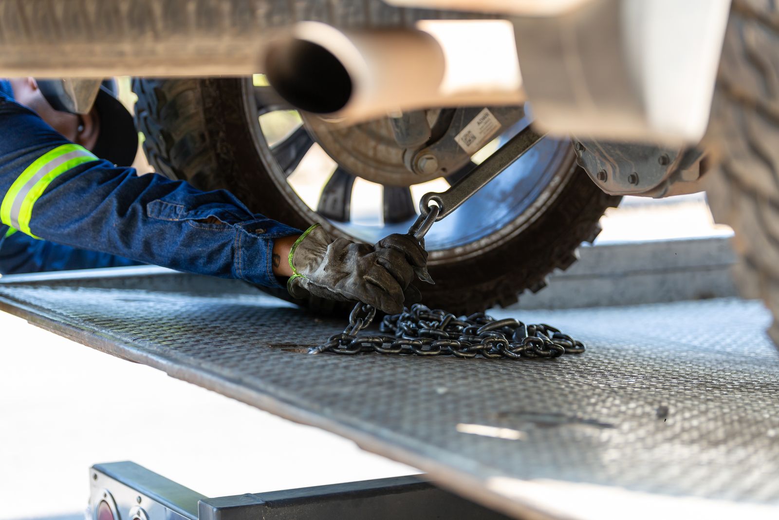 Operator securing a vehicle with a tow chain