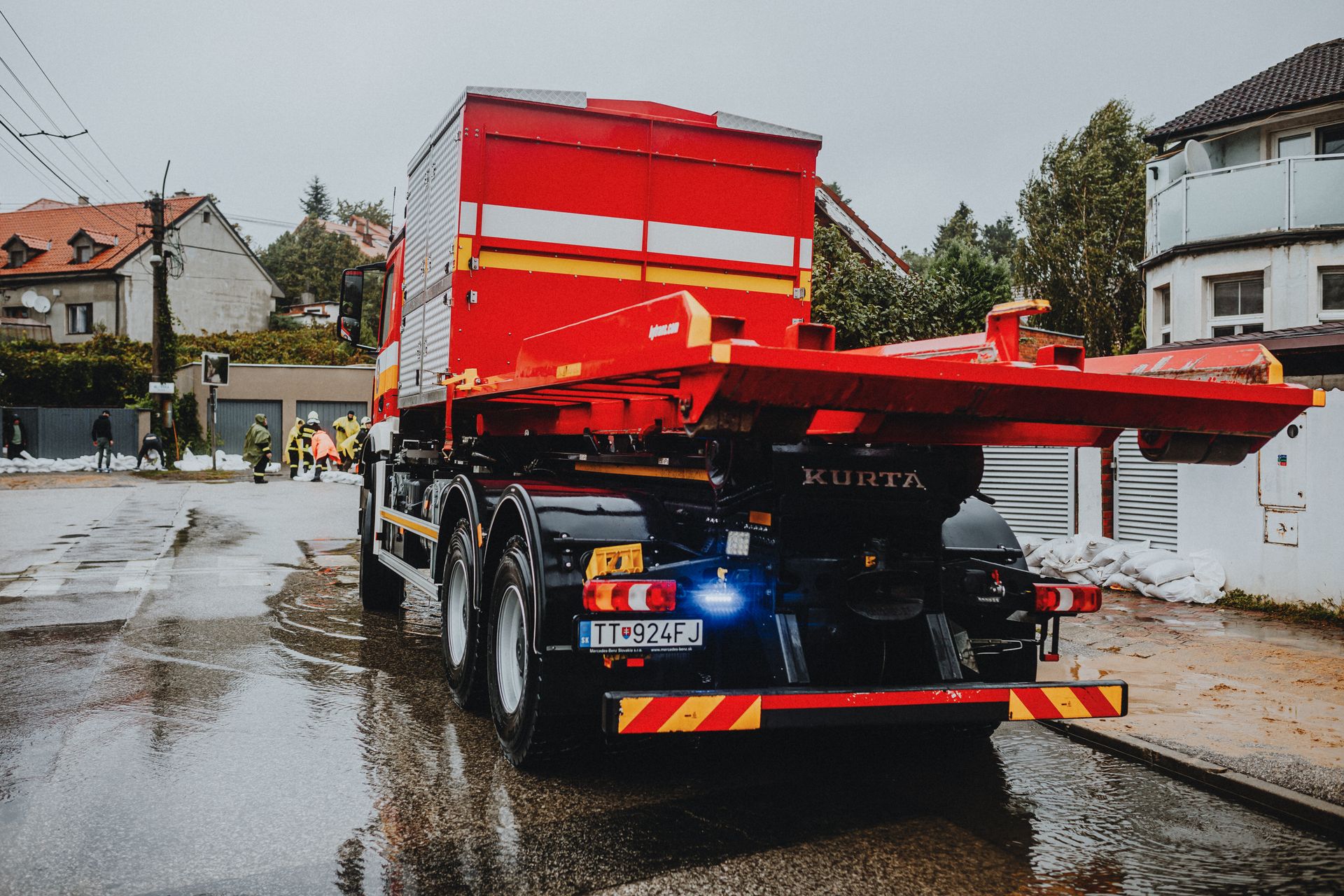 Red tow truck on a wet city street at dusk